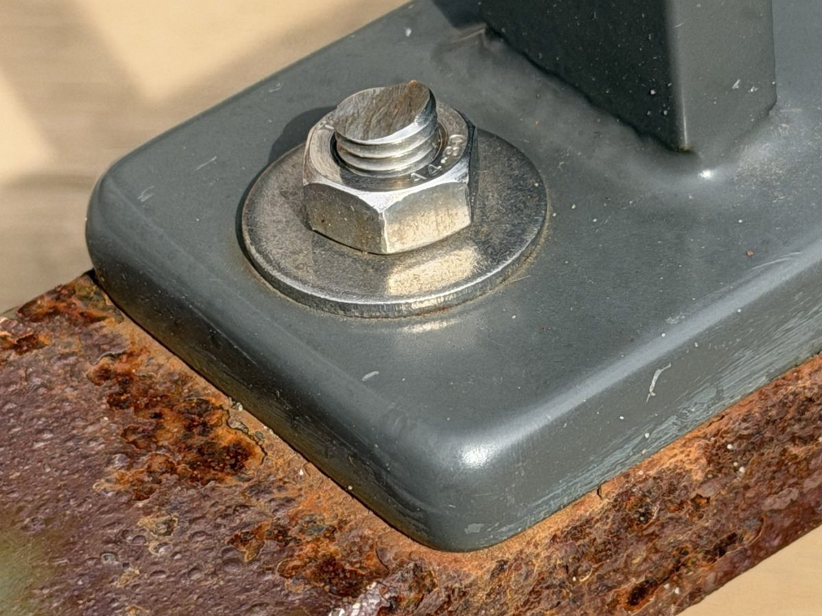 RVS bout in een gecoate voetplaat op een roestende stalen koker
