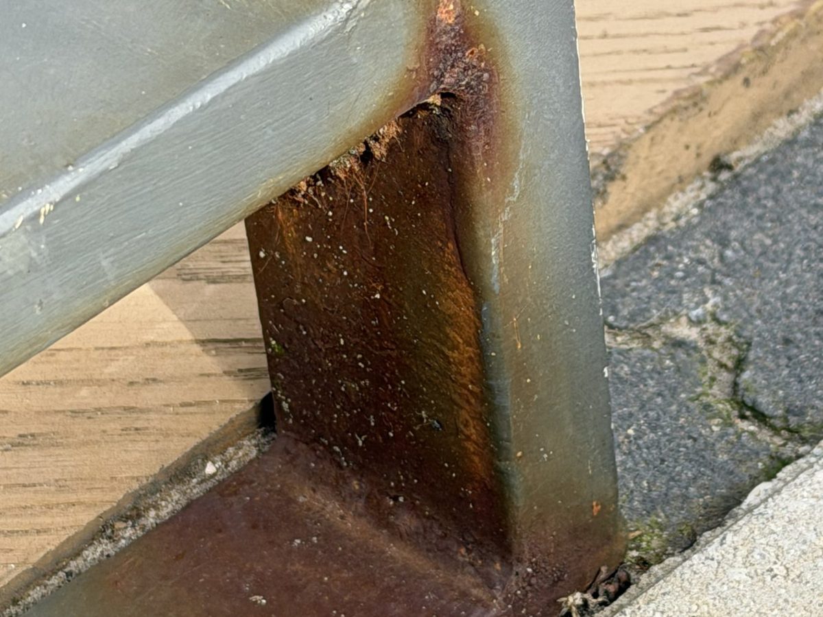 Roestvorming bij de hoekverbinding van het hekwerk, met roestwater op het terras