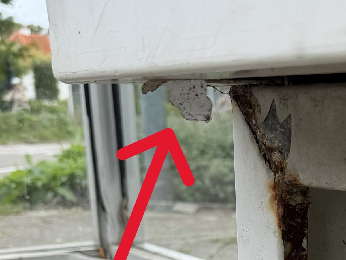 Losgelaten coating aan de scherpe onderrand van het zitje, met roest langs de rand van de poot