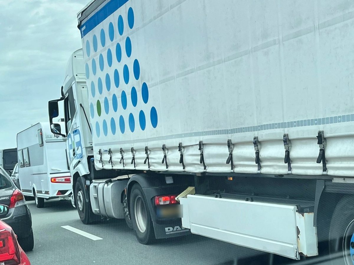 Vrachtwagen op de snelweg met een witte palletkist onder de oplegger